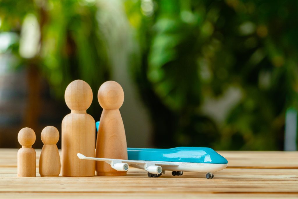 Family travel and vacation concept. Wooden figures of family and toy plane